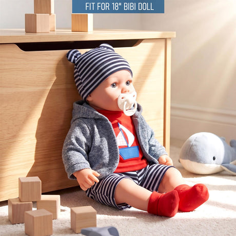 A doll is shown wearing a striped hat, grey cardigan, red and blue striped shorts, and red socks.