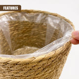 Close-up of a woven, tan wicker planter with a layer of clear plastic sheeting inside.