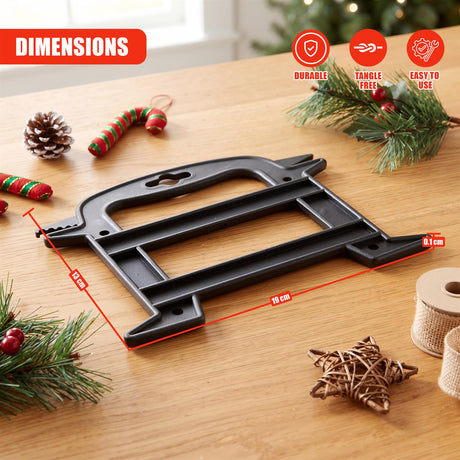 Black Christmas light reel storage on a wooden table surrounded by festive decorations