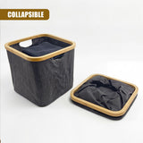 Gray fabric laundry hamper standing next to the rectangular, framed, folded unit.