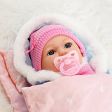 A doll wearing a pink knitted cap and sitting in a pink stroller.