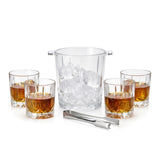 Four whiskey glasses containing amber liquor surround a clear ice bucket and metal scoop.