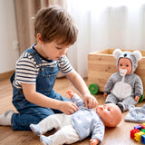Boy plays with two dolls wearing matching polar bear and koala animal outfits.