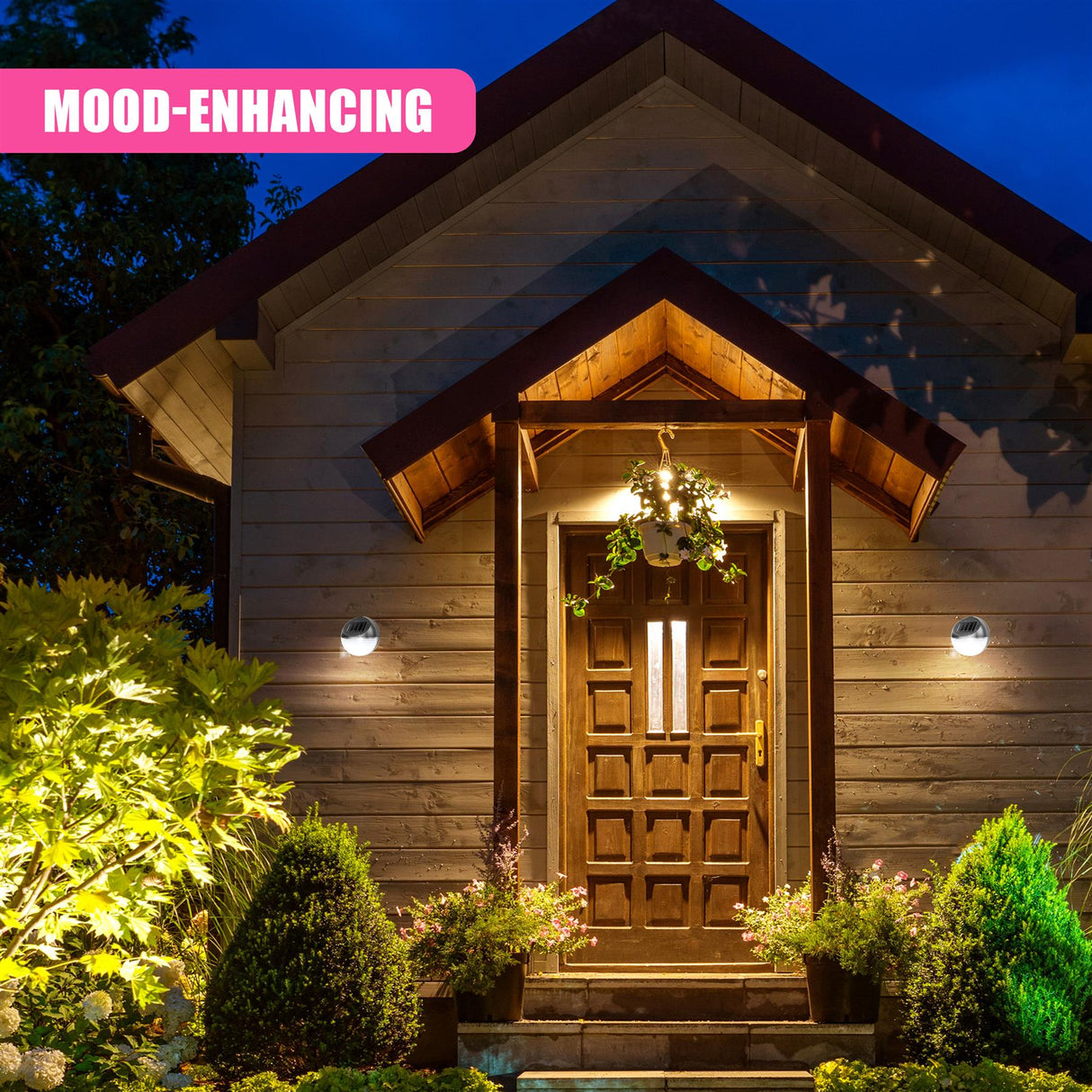 A set of illuminated outdoor sconce lights frames the wooden front entrance door.