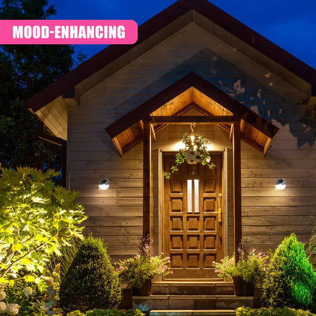 A set of illuminated outdoor sconce lights frames the wooden front entrance door.