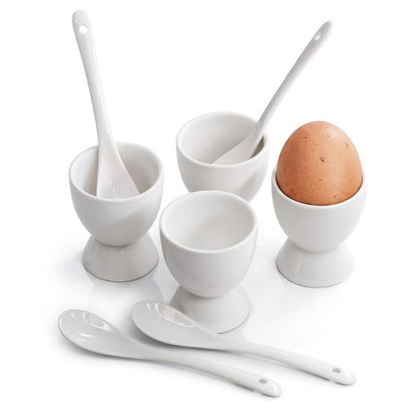 A set of four white ceramic egg cups with matching spoons, one holding a brown egg, displayed on a white background