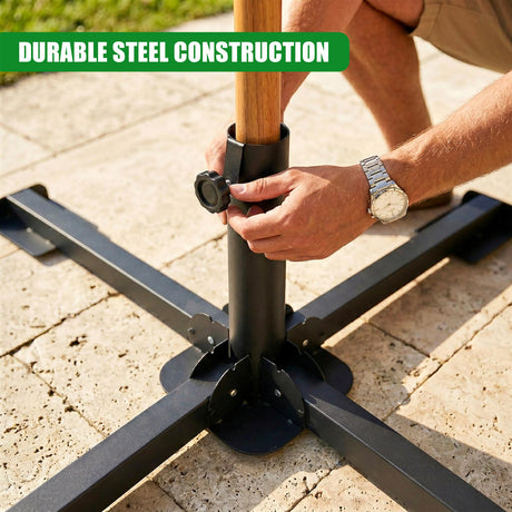 A person's hands hold the central pole connecting dark metal arms to the ground base.