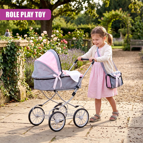 A young girl pushing a pink and gray doll pram while standing on a paved garden path.