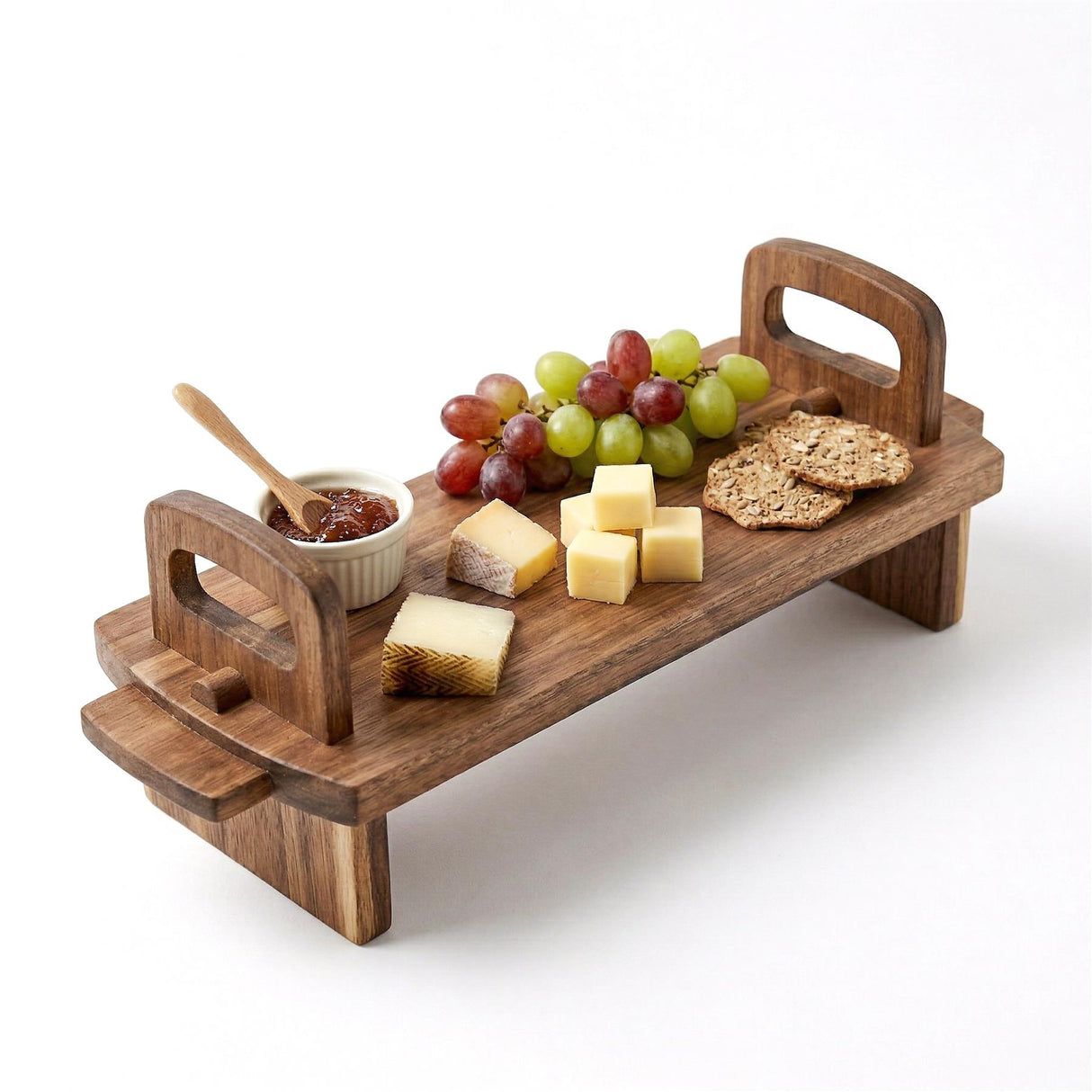 Acacia wood platter displaying grapes, cheese cubes, crackers, dip, and dipping utensil.