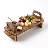 Acacia wood platter displaying grapes, cheese cubes, crackers, dip, and dipping utensil.