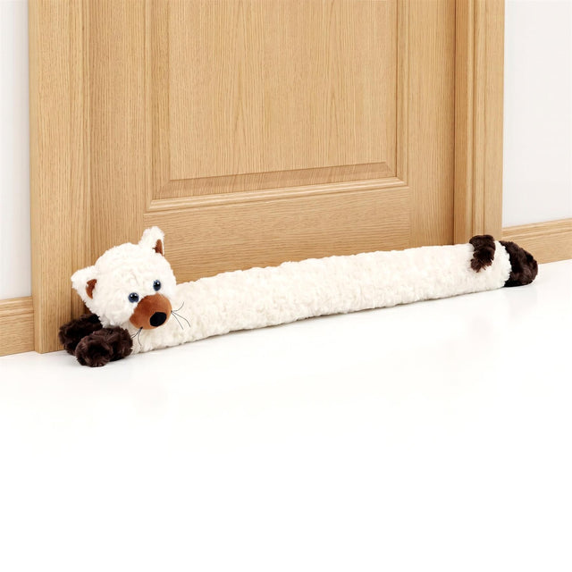 Cream cat novelty draught excluder with black paw details rests against a wooden door.