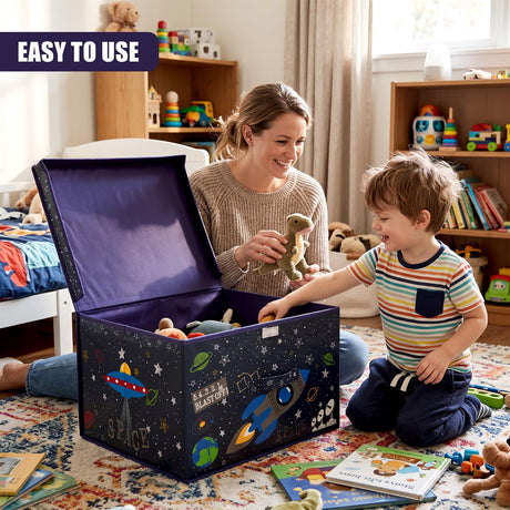 A smiling woman and young boy play with toys inside a large space-themed storage box on a rug