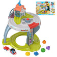 The toy table features train tracks, a station house, a small engine, and various colored geometric blocks.