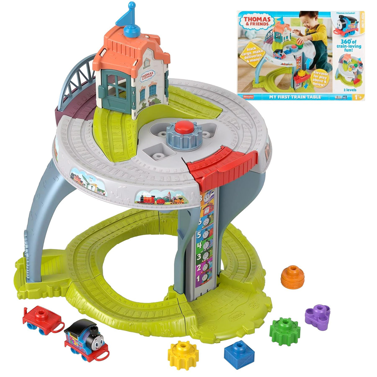 The toy table features train tracks, a station house, a small engine, and various colored geometric blocks.