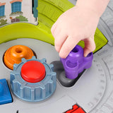 Close-up view of a hand attaching a purple train piece to the structured plastic toy table.