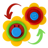 Three brightly colored silicone baby teethers feature smiling faces in red and green.