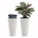 Two tall, white ribbed planters—one empty and one containing a variegated houseplant.