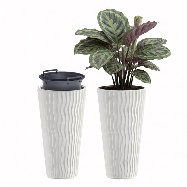 Two tall, white ribbed planters—one empty and one containing a variegated houseplant.