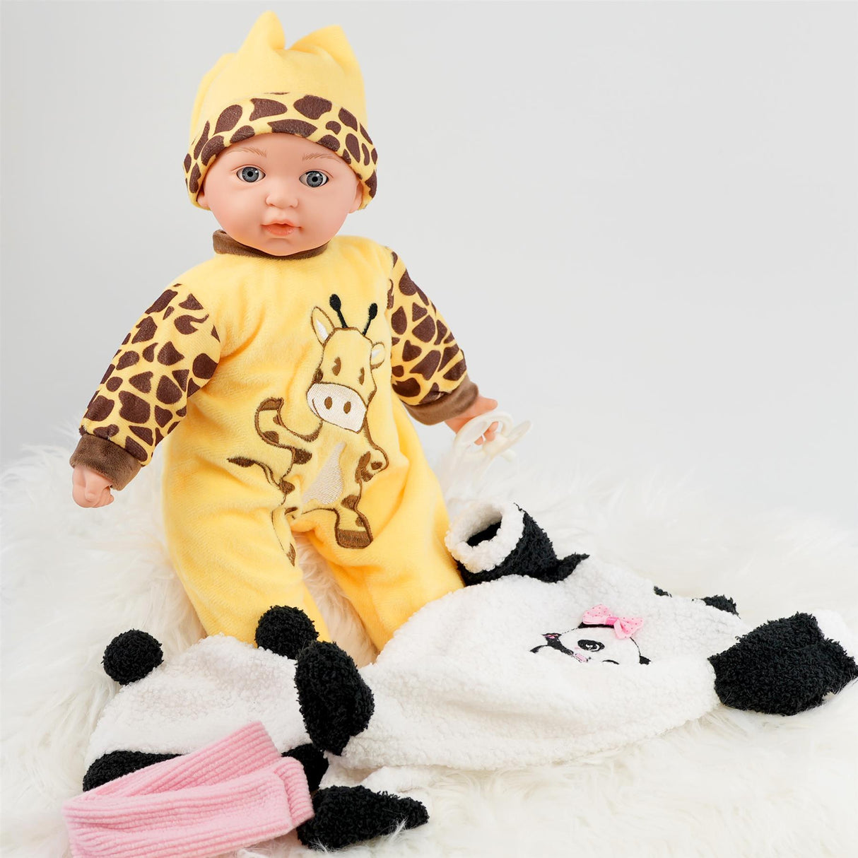 A baby doll in a zebra costume on display with a stuffed animal in the background.