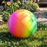 Rainbow spectrum gradient on a large sphere placed outdoors on green lawn and grass.