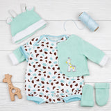 Set of baby clothes including spotted bodysuit, mint jacket, crocheted hat, booties, and wooden toy.