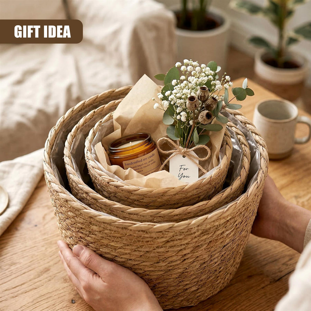 Hand holding a nested trio of woven wicker planters filled with flowers and small gifts.