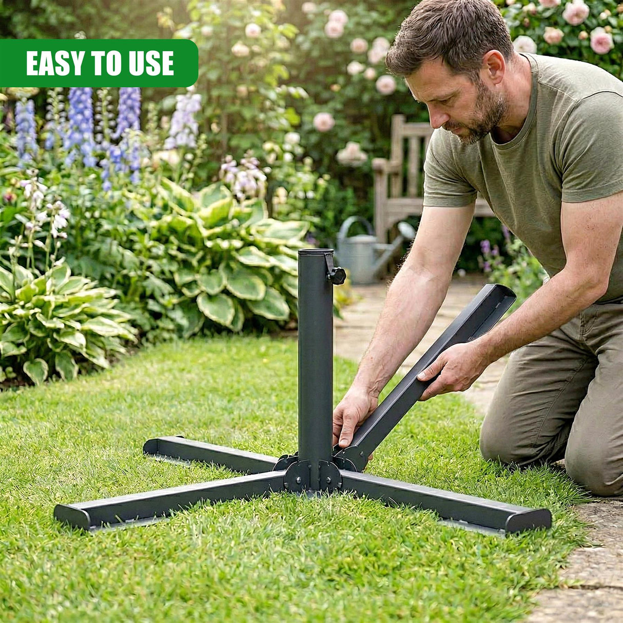 Metal foldable parasol base being assembled on a bright green grass lawn.