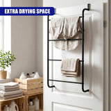 Black ladder-style towel rail mounted on a white door, holding draped towels and clothes.