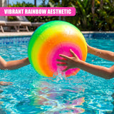 A rainbow-colored inflatable ball floats in clear blue pool water, held by visible hands.