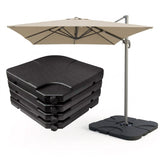 Beige patio umbrella on a stand next to a stack of four dark square outdoor cushions.