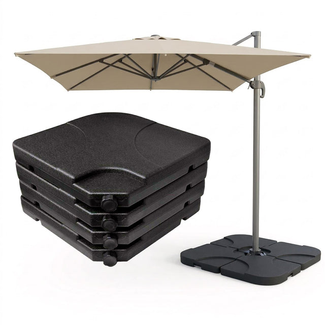 Beige patio umbrella on a stand next to a stack of four dark square outdoor cushions.