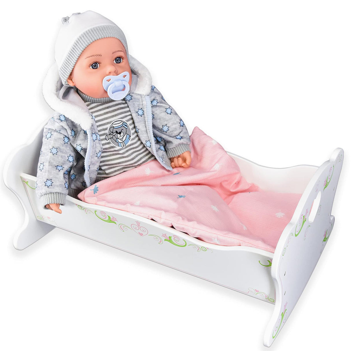A doll in a jacket and hat lying in a pink-lined white wooden baby cradle.