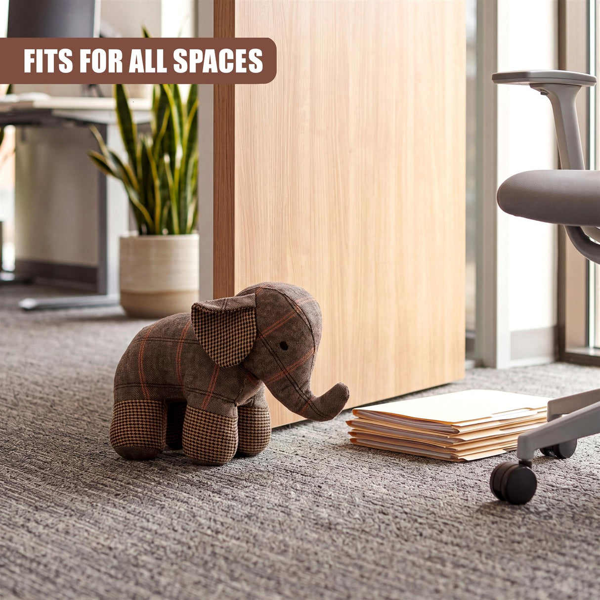 Tartan elephant door stopper rests on a carpet near stacked paper and desk accessory.