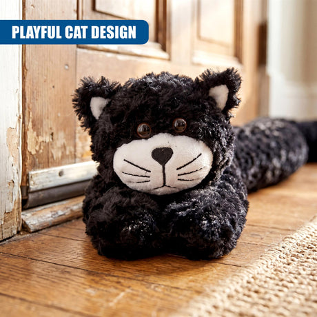 Fluffy black cat draught excluder resting on a wood floor near an old door.