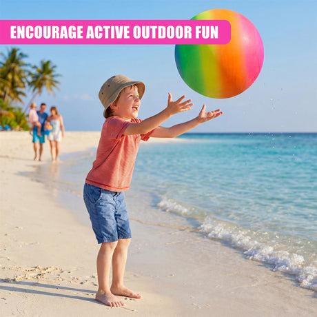 Boy on the beach plays with a large, rainbow-colored ball near the ocean and sandy shoreline.