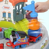A hand adds a blue track piece to the Thomas & Friends playset with a train and stacked tracks.