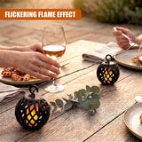 Black, patterned string lights draped over a rustic wooden table with wine and appetizers.