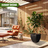 Textured, charcoal black square planter displayed next to tropical green plants and wood paneling.