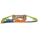 Toy playset features train engine, wagons, a wooden bridge structure, and curved track section.