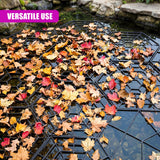 Autumn leaves rest on a black hexagonal floating grid placed over dark pond water.